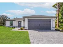 Single-story home with gray garage door and landscaped lawn at 4621 Kenoska St, North Port, FL 34288