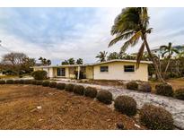 Ranch style home with a palm tree and landscaping at 601 Ambassador Ln, Holmes Beach, FL 34217