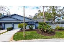 Inviting exterior of a light blue house with well-manicured landscaping at 90 Morning Dove Pl, Oldsmar, FL 34677