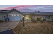 Front view of a single story home with stone exterior and attached garage at 1207 Eastloch Ct, Sun City Center, FL 33573