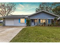Cute ranch home with blue exterior, stone accents, and a well-manicured lawn at 2166 Temple Ter, Clearwater, FL 33764