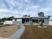 Ranch-style home with gray exterior, white fence, and landscaped yard at 4059 Benson N Ave, St Petersburg, FL 33713