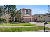 Charming two-story home with a well-manicured lawn and three-car garage at 4161 Grandchamp Cir, Palm Harbor, FL 34685
