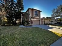 Two-story house with a two-car garage and manicured lawn at 4161 Grandchamp Cir, Palm Harbor, FL 34685