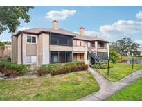 Two-story condo building with balconies, landscaping, and a walkway at 10263 Gandy N Blvd # 2206, St Petersburg, FL 33702