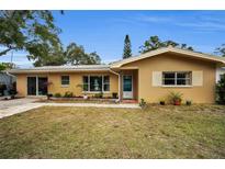 Charming single-story home with a well-maintained lawn and tidy landscaping at 1034 Sunnydale Dr, Clearwater, FL 33755