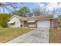 Ranch-style home with stone accents and a spacious driveway at 12512 River Mill Dr, Hudson, FL 34667