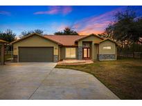 Single-story home with attached garage and attractive landscaping at 18010 Okeene Dr, Hudson, FL 34667