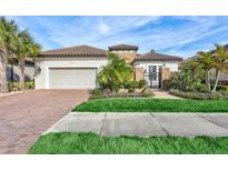 Single-story home with tile roof, stone accents, and landscaped yard at 20105 Umbria Hill Dr, Tampa, FL 33647