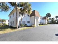 White two-story building with brown roof, landscaping, and parking at 207 S Mcmullen Booth Rd # 198, Clearwater, FL 33759