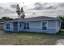 Newly constructed home with gray exterior, landscaping, and a spacious yard at 5352 Tangerine Dr, New Port Richey, FL 34652