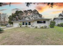 Charming ranch home with well-manicured lawn and sunset view at 553 Lake Hill Ln, Largo, FL 33771