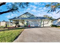 House exterior featuring a two-car garage and well-maintained lawn at 803 Innergary Pl, Valrico, FL 33594