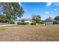 Ranch-style home with a large yard and driveway at 13000 Club Dr, Hudson, FL 34667