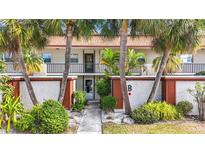 Inviting condo building with lush landscaping and palm trees at 2750 E Bay Dr # 3B, Largo, FL 33771