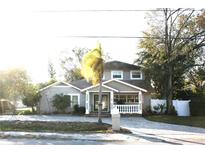 Two-story house with gray brick, landscaped yard, and a paved driveway at 8006 N Rome Ave, Tampa, FL 33604