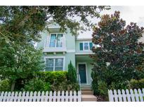 Two-story light green house with white picket fence and landscaping at 11125 Winthrop Lake Dr, Riverview, FL 33578