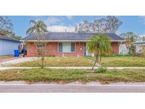 Brick home with a well-maintained lawn at 120 80Th N Ave, St Petersburg, FL 33702