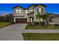 Two-story home with stone accents and a three-car garage at 14690 Horse Trot Rd, Lithia, FL 33547