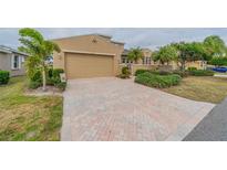 Tan two-story house with a three-car garage and paved driveway at 2431 Kensington Greens Dr # 0, Sun City Center, FL 33573