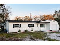 Newly renovated single-story home featuring a white exterior, black shutters, and a landscaped front yard at 5109 Gateway Dr, Tampa, FL 33615