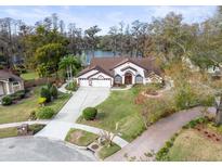 Stunning aerial view of a house with a large backyard, a lake, and lush landscaping at 5649 Glencrest Blvd, Tampa, FL 33625