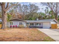 Gray Ranch home with a blue front door and mature landscaping at 7000 Dr Martin Luther King Jr S St, St Petersburg, FL 33705