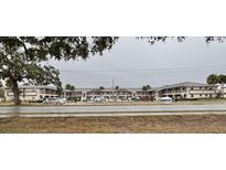 Exterior view of a condo building with parking and landscaping at 7400 Spring Hill Dr # 209, Spring Hill, FL 34606