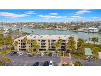 Aerial view of waterfront condo building with parking and recreational areas at 7537 Bayshore Dr # 406, Treasure Island, FL 33706