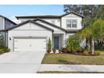Two-story house with a neutral color scheme, landscaping, and a two-car garage at 14146 Samoa Hill Ct, Riverview, FL 33569