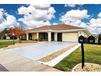 Single-story home with attached garage and landscaped yard at 1613 Faxton Dr, Sun City Center, FL 33573