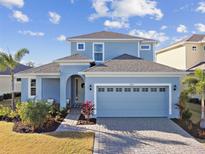 Charming two-story home featuring a two-car garage, well-manicured lawn, and beautiful landscaping at 949 Signet Dr, Apollo Beach, FL 33572