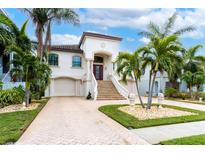 Stunning two-story home with a grand entrance and meticulously landscaped grounds at 105 Wimbledon Ct, Redington Shores, FL 33708