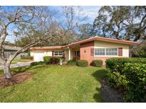 Ranch style home with brick facade, mature landscaping, and a spacious yard at 1320 Fairway Dr, Dunedin, FL 34698