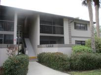 Exterior view of condo building with stairs and landscaping at 1515 Forrest Nelson Blvd # E108, Port Charlotte, FL 33952