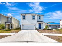 Two-story house with white exterior, two-car garage, and landscaped lawn at 17033 Oval Rum Dr, Wimauma, FL 33598