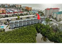 Aerial view of condo building near beach, pool, and lush landscape at 19727 Gulf Blvd # C-1, Indian Shores, FL 33785