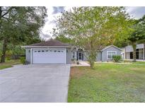 House exterior boasts a white garage door and well-manicured lawn at 38902 Inez Ave, Zephyrhills, FL 33542