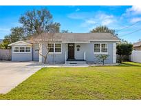 Charming Bungalow style home with gray exterior, landscaped lawn, and driveway at 4424 W Bay Villa Ave, Tampa, FL 33611