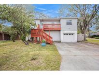 Two-story house with a deck, garage, and landscaped yard at 5004 Osprey Ln, New Port Richey, FL 34652