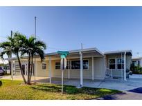 Tan single-story home with carport and palm trees in front at 544 Skipper Dr # 544, Seminole, FL 33772