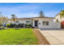 White single-story home with a lush green lawn and a driveway at 5934 Bayou Grande Ne Blvd, St Petersburg, FL 33703