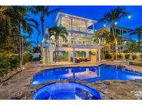 Stunning pool and patio area with a spa, outdoor seating, and beautiful landscaping at 644 Boca Ciega Isle Dr, St Pete Beach, FL 33706