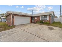 Brick ranch home with attached garage and landscaped front yard at 6950 113Th St, Seminole, FL 33772