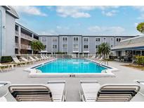 Refreshing community pool with lounge chairs and patio area at 701 Poinsettia Rd # 302, Belleair, FL 33756