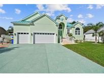 Beautiful light green house with a three-car garage and lush lawn at 711 Eagle Ln, Apollo Beach, FL 33572