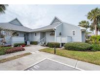 Light blue exterior of condo with walkway, landscaping, and parking at 1018 Caravel Ct, Tarpon Springs, FL 34689