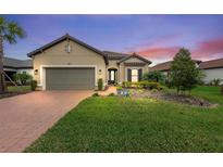 Single-story home with a two-car garage and landscaped front yard at 10804 Wicker Park Pl, Palmetto, FL 34221