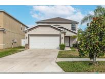 Two-story house with attached garage, landscaping, and a driveway at 1966 Hawks View Dr, Ruskin, FL 33570