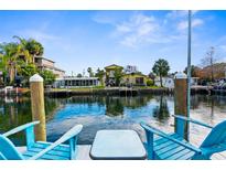 Relaxing waterfront view with blue Adirondack chairs and a table at 5421 Circle Dr, Weeki Wachee, FL 34607